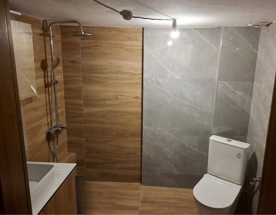 Μπάνιο με έπιπλο μπάνιου σε φυσικές αποχρώσεις και καμπίνα ντους, παράδειγμα ολοκληρωμένου σχεδιασμού